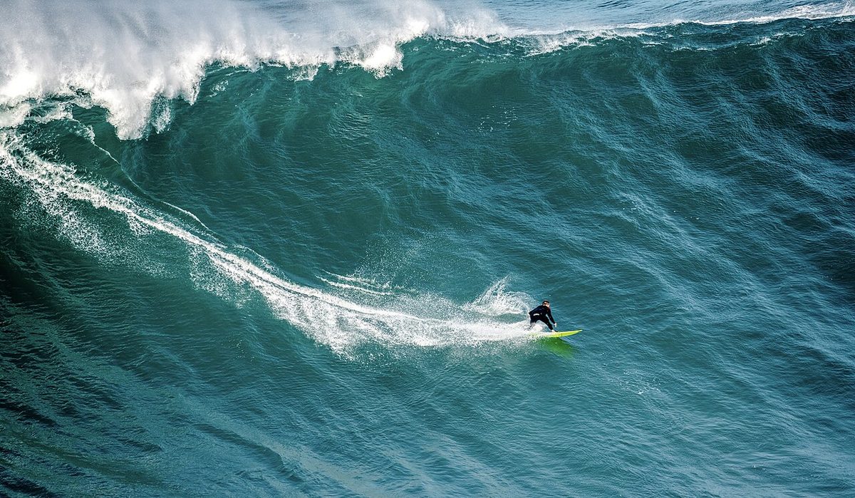 A surfer riding a big wave at Praia do Norte in Nazare
