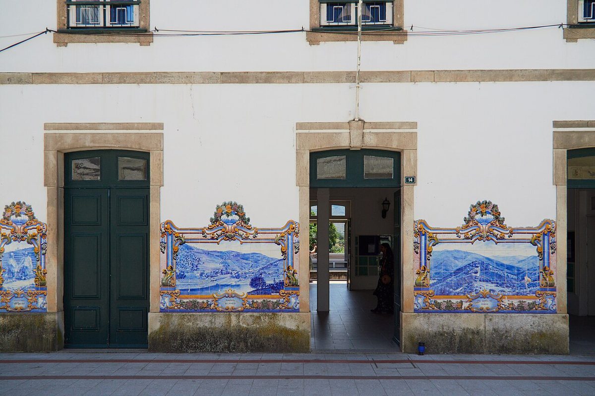 Blue and white azulejo panels showing the grape harvest on the platform wall at Pinhao station