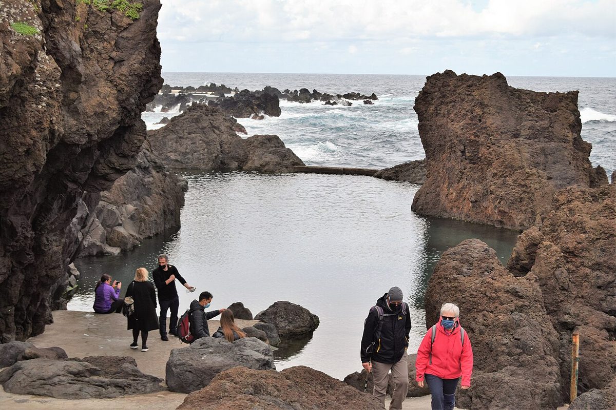 Visitors beside the natural volcanic rock pools at Porto Moniz on Madeira's north coast
