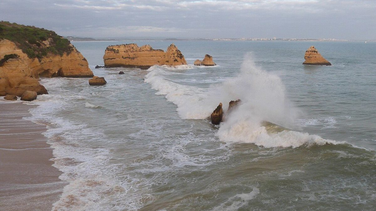 Winter surf breaking over limestone stacks on the Algarve coast near Lagos