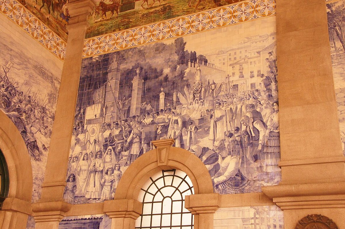 Blue and white azulejo panels showing a royal procession covering the walls of São Bento station in Porto