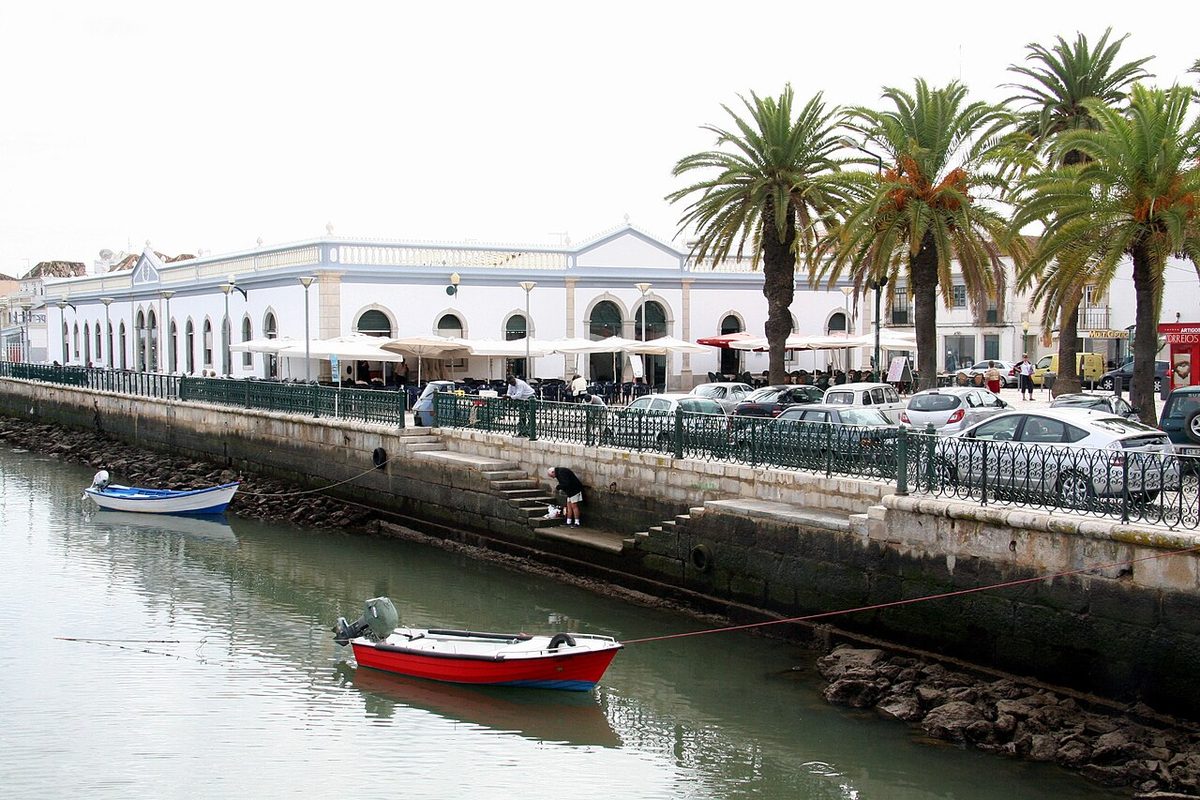 The riverside market building and small moored boats on the Gilao at Tavira in the eastern Algarve